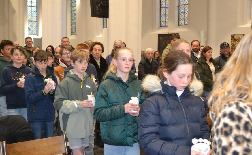 Vormelingen dragen hun knutselwerkje met brandend theelicht 