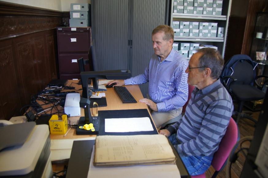 Willy Van De Pol en Jef Verdonck bezig met de scanning van het kerkarchief    in de  werkkamer van ‘Zeven Neten’. Bij afwezigheid van Willy valt Frank de Ceulaer in. © Jef Verdonck