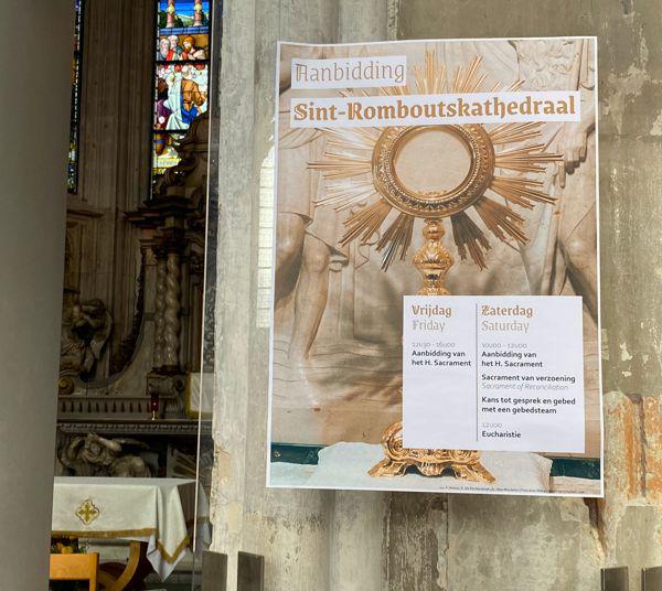 Affiche informeert bezoekers van de Mechelse Sint-Romboutskathedraal over wekelijkse aanbiddingsmomenten in de weekkapel. © Hans Medart
