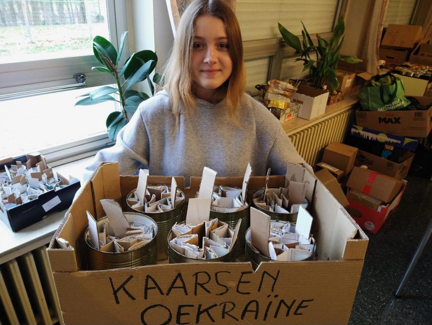 Angelina met enkele blikken om te vullen. Deze kaarsen branden zo’n 20 uur © Pastorale zone Leuven aan de Dijle