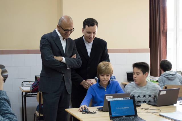 Microsoft-CEO Nadella (l.) kijkt toe hoe een leerling met Minecraft werkt.