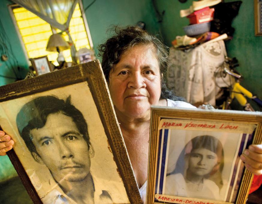 Een nabestaande uit Santa Lucia Cotzumalguapa toont portretten van familieleden die omkwamen bij de boerenprotesten in de jaren 1980. © Piet den Blanken