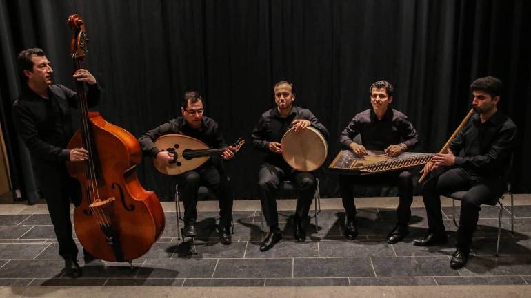 Het Wajdensemble met zanger en percussionist Khaled Alhafez in het midden. Het Wajdensemble met zanger en percussionist Khaled Alhafez in het midden.